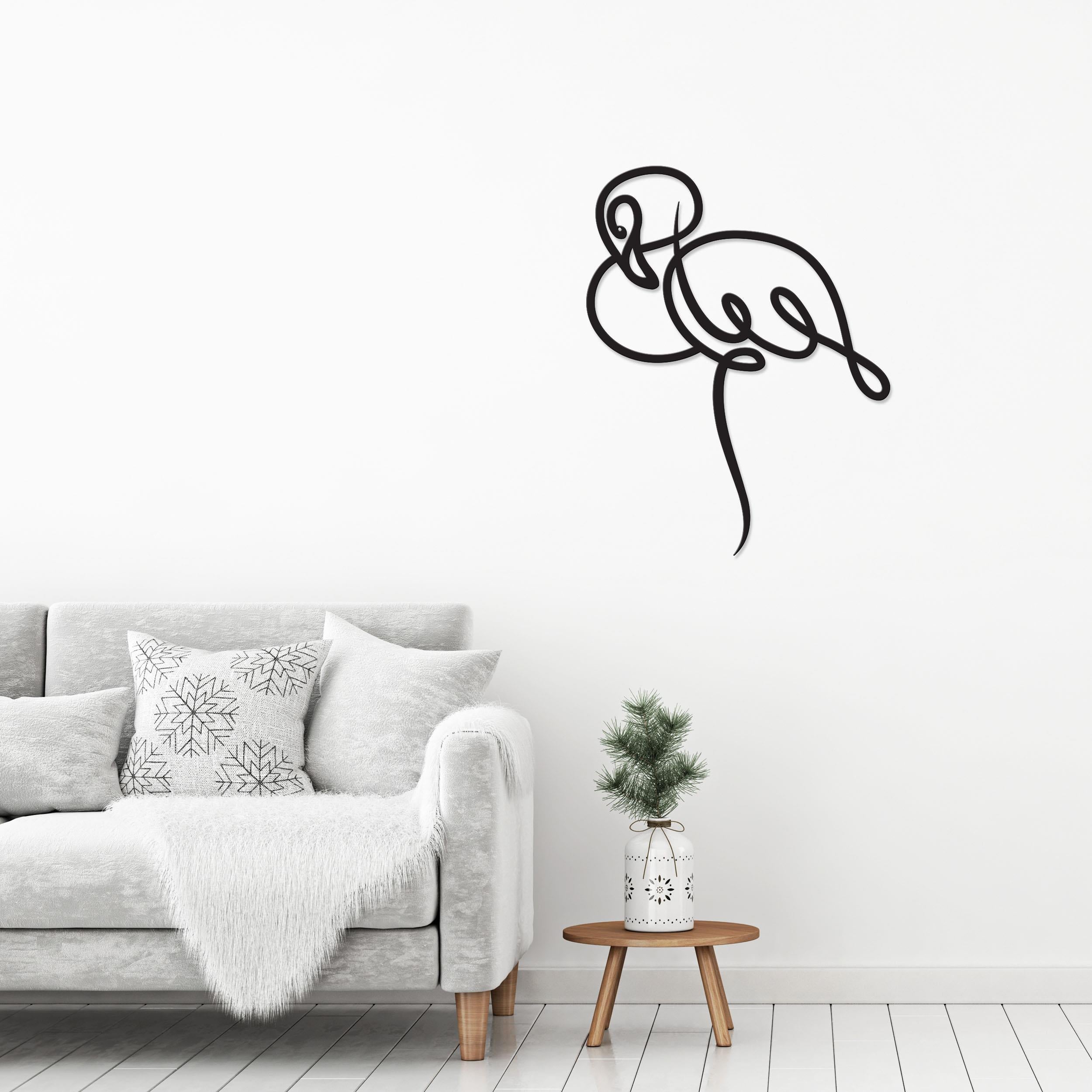 Flamingo metal wall art in Texture Black hung above a sofa in a living room, 47x60cm