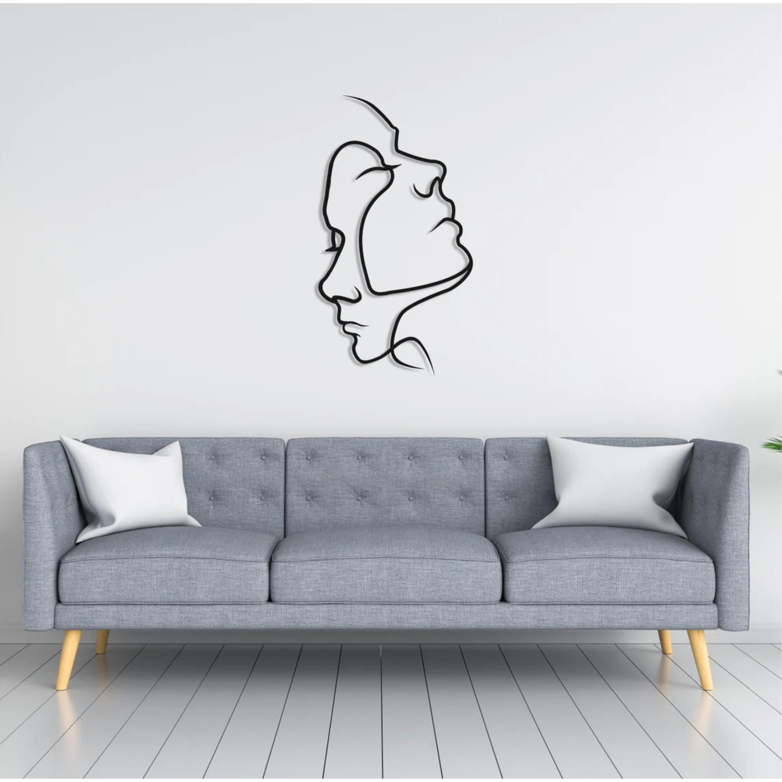 Two Face Metal Wall Art (75x42cm) in Texture Black, hung above a sofa
