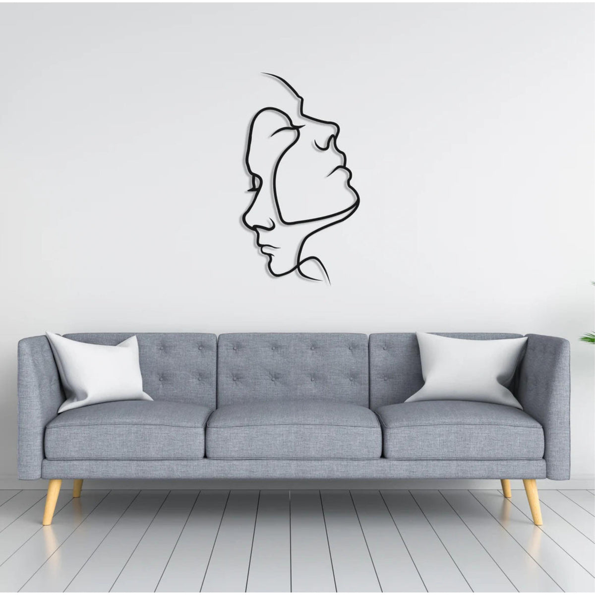 Two Face Metal Wall Art (75x42cm) in Texture Black, hung above a sofa